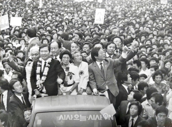 군중의 뜨거운 환호를 받고 있는 김대중-이희호 부부가 서 있는 차 뒤편으로 유준상 전 의원의 얼굴이 보이고 있다.©사진제공=유준상